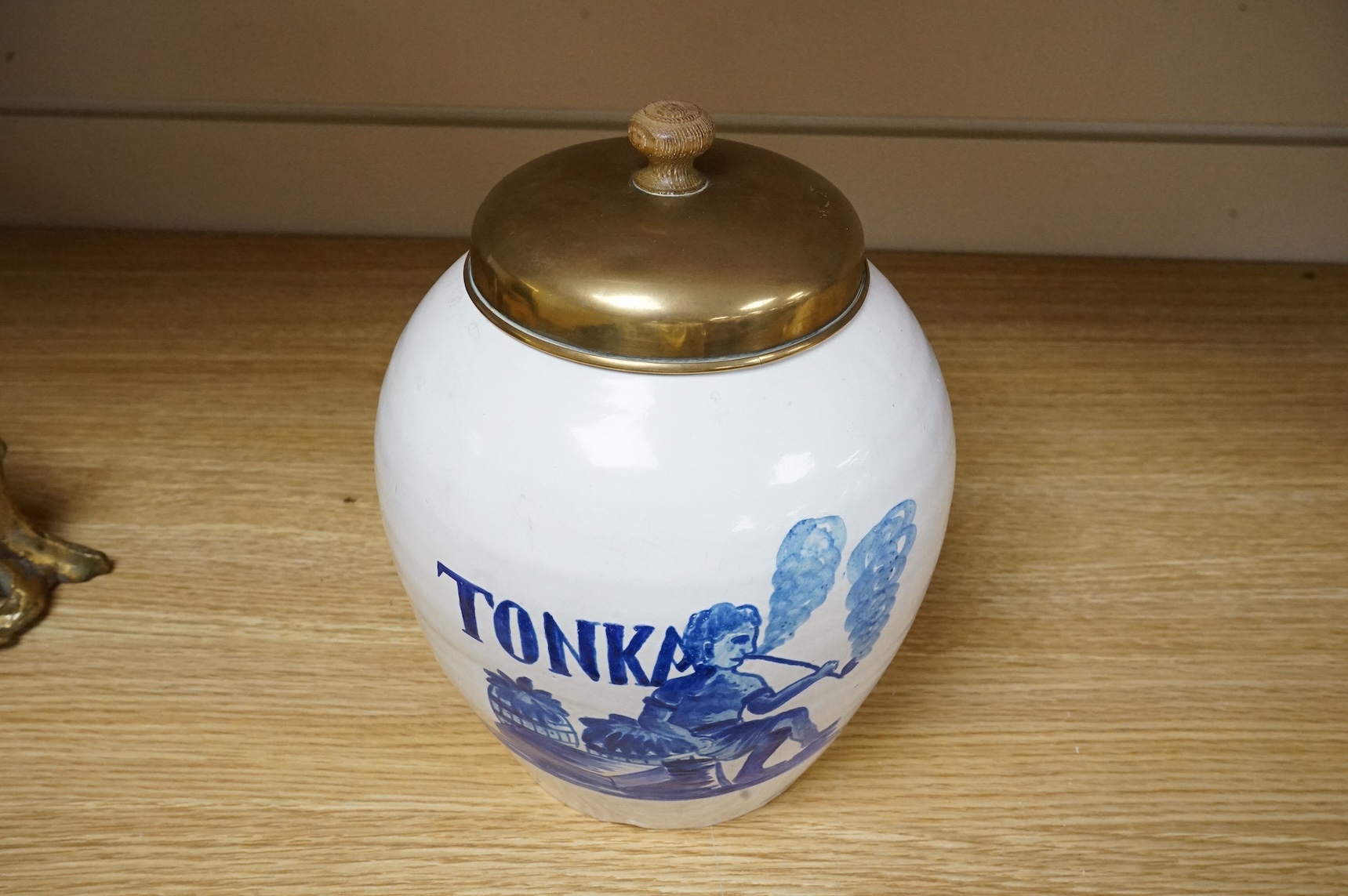 A pottery blue and white figural drug jar with brass cover, 24cm including cover.